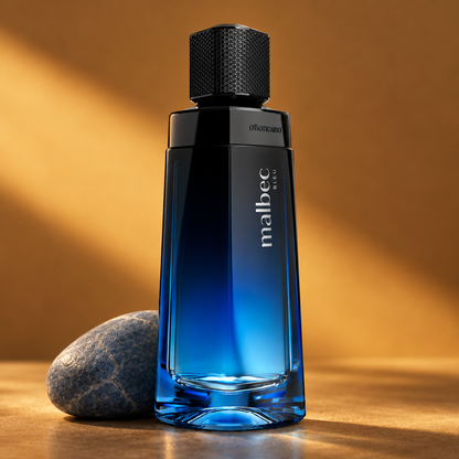 Malbec Bleu Eau de Parfum em cenário minimalista com pedra cinza-azulada e fundo âmbar